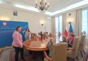 Dzieci siedzące przy stole w sali posiedzeń.
