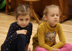Dziewczynki słuchają instrukcji nauczycielki.