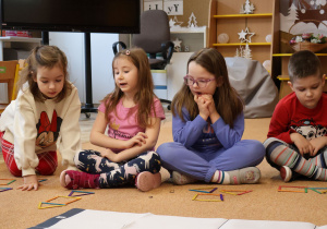 Dzieci układają figury geometryczne z kolorowych patyczków.