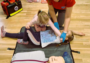 Przedszkolaki ćwiczą ułożenie bezpieczne dla poszkodowanego.