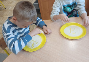 "pisanie" na tacy z kaszą