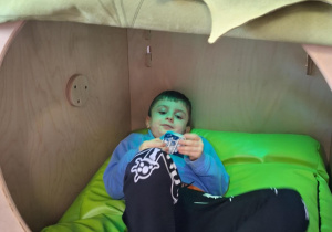 chłopiec bawi się gniotkiem w kryjówce