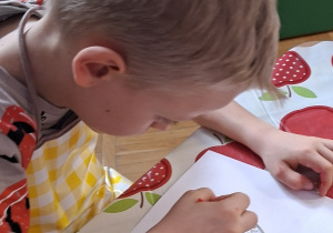 chłopiec ozdabia witrażyk