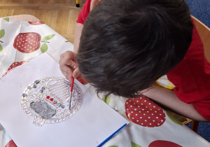 chłopiec ozdabia witrażyk