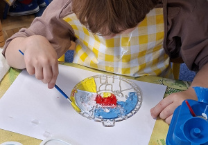 chłopiec ozdabia witrażyk