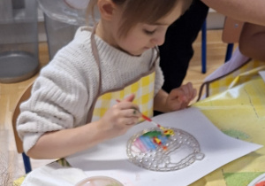 dziewczynka ozdabia witrażyk