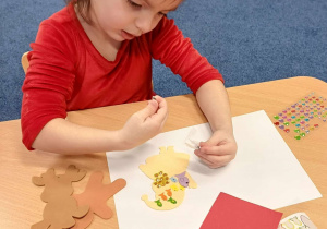 dziewczynka klei ozdoby