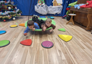 chłopcy bujają się w gnieździe bocianim