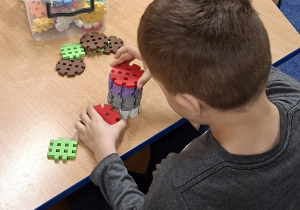 chłopiec buduje z klocków