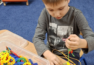 chłopiec bawi się nawlekanką