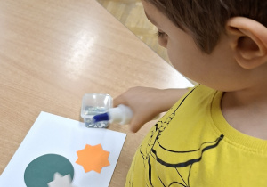 chłopiec robi pracę plastyczną